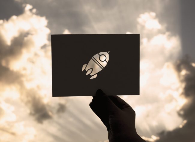 Hand Hold Space Rocket Paper Carving with Sky Background